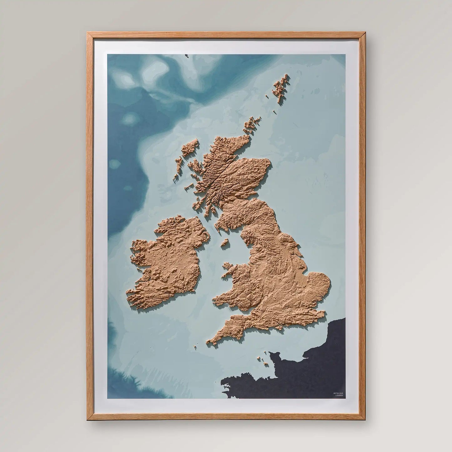 Framed 3D topographic map of Scotland, England and Ireland inside an oak frame on a light grey wall – TerraFrames