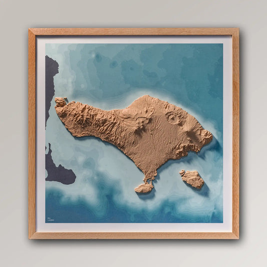 Framed 3D topographic map of Bali, 40x40cm art board inside an oak frame on a light grey wall – TerraFrames