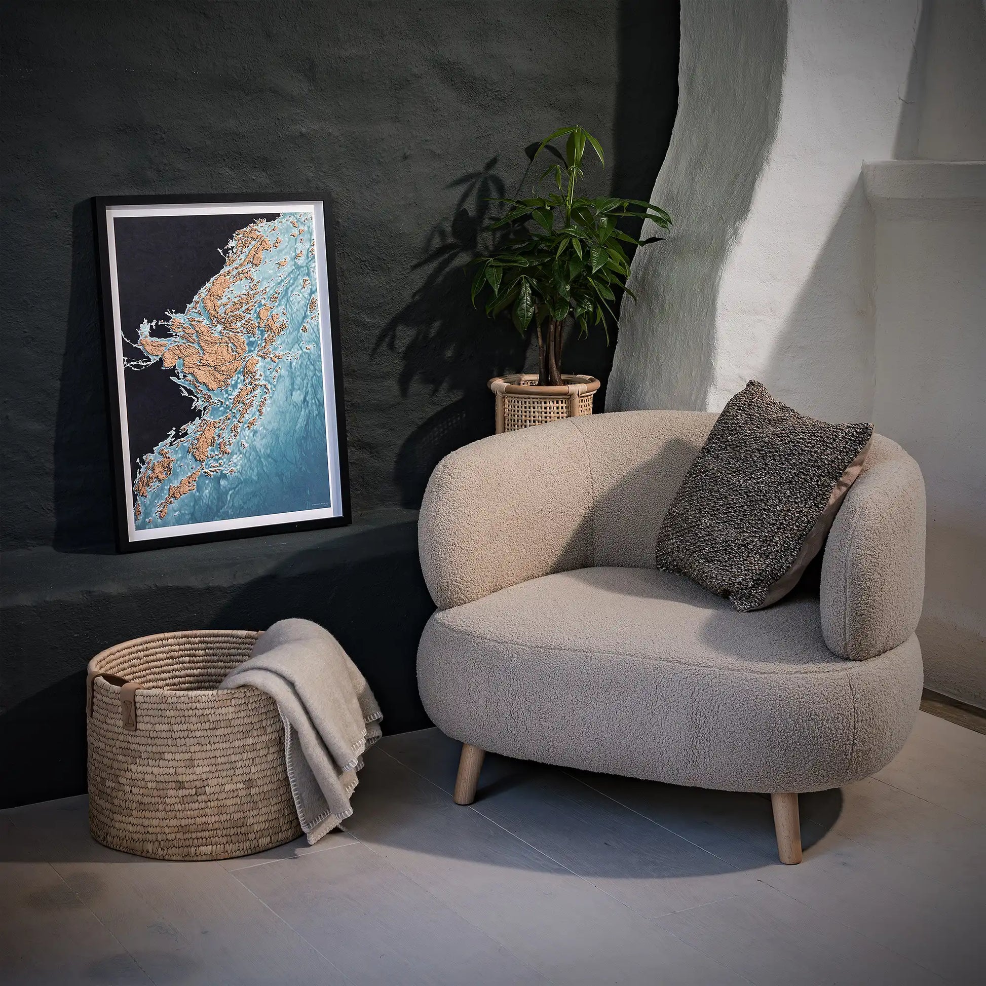 Framed 3D topographic map of Stockholm's archipelago in a minimalist room with a beige armchair and a black wall – TerraFrames