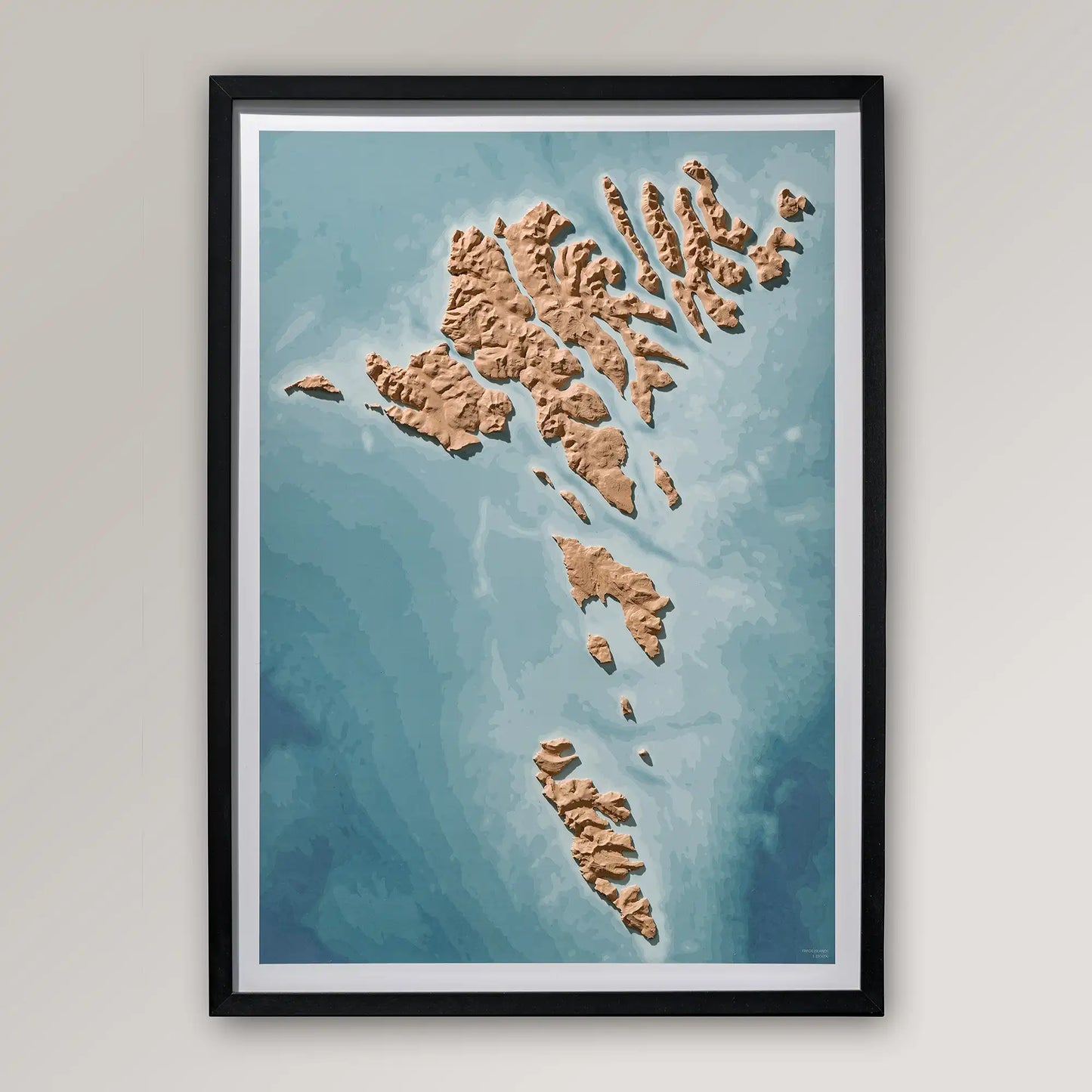 Framed 3D topographic map of the Faroe Islands inside a black frame on a light grey wall – TerraFrames